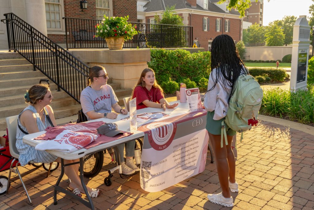 HES Community, Engagement, and Outreach Student Organization speaking with a student about the organization.