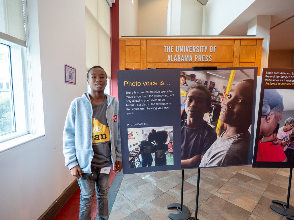 Young man standing with a poster